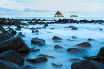 Rocks in sea against sky