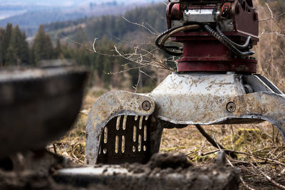 Close-up of rusty machine part on field