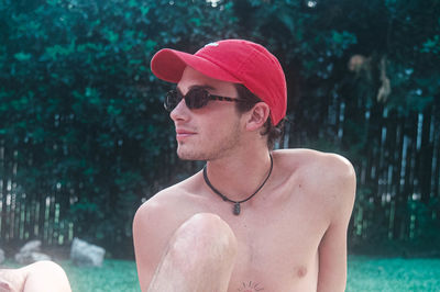 Portrait of young man wearing sunglasses against trees