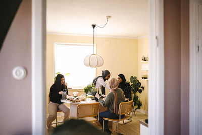 Young female friends preparing food together in kitchen at home