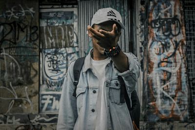 Full length of person standing against graffiti wall