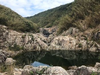 Scenic view of river amidst mountains against sky