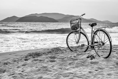 Bicycle on beach against sky