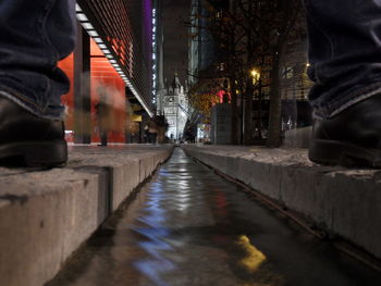 Low section of man in illuminated city at night