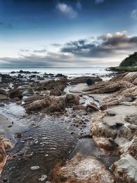 Rocks on beach against sky