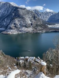 Scenic view of frozen lake by snowcapped mountains in hallstatt austria 