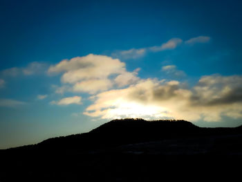 Low angle view of silhouette mountain against sky at sunset