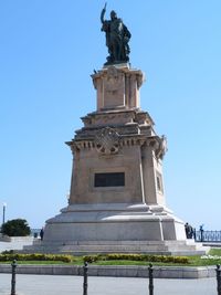 Low angle view of statue against clear blue sky