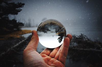 Close-up of hand holding crystal ball