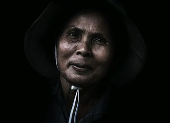 Portrait of mature woman against black background