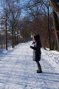 A woman standing on a snowy rural road