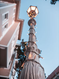 Low angle view of illuminated street light against sky