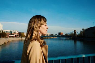 Millennial caucasian woman standing at riverfront and enjoy with sunny day