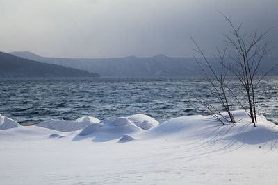 Scenic view of lake against sky during winter