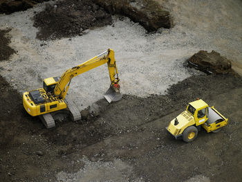 Aerial shot of steamroller and earth mover on building plot