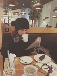 Woman sitting on table in restaurant