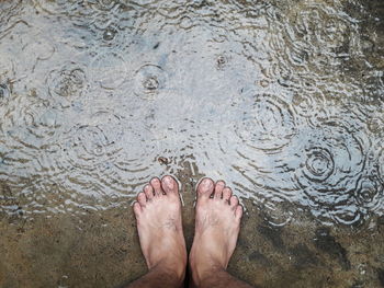 Low section of woman standing in water