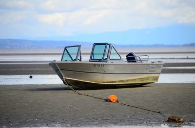 Boats in sea against cloudy sky