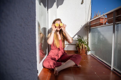 Woman with pink flowers against wall