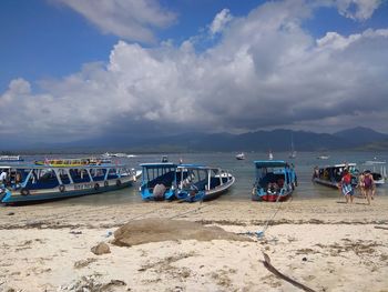 Boats moored on beach against sky