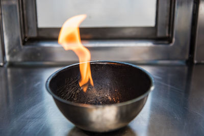 Close-up of burning candle on table at home