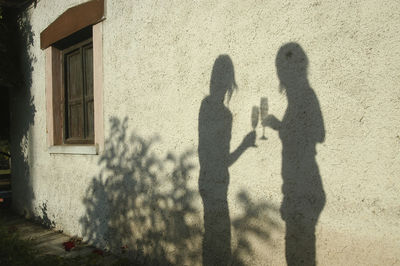 Shadow of man standing against wall