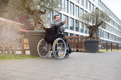 A physically disabled person on a wheelchair at a walk.