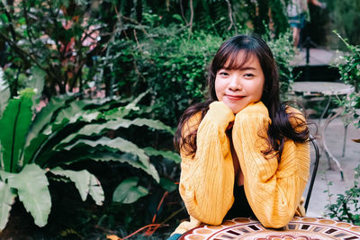 Portrait of young woman sitting outdoors