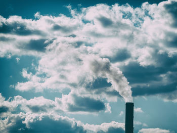 Low angle view of smoke stacks against sky