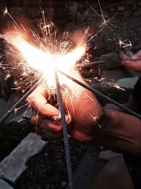 Close-up of hand holding sparkler at night