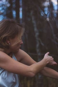 Close-up of young woman dancing in forest