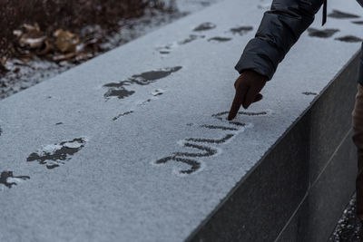 Cropped hand of person writing on snow