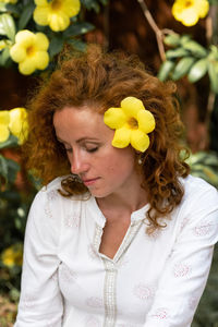 Portrait of young woman holding red flowers