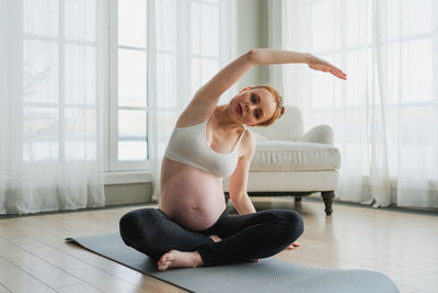 Portrait of young woman exercising at home