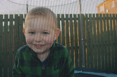 Portrait of smiling boy seen through netting