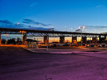 Illuminated bridge over river against blue sky