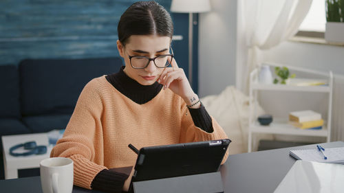 Young man using phone while sitting at home