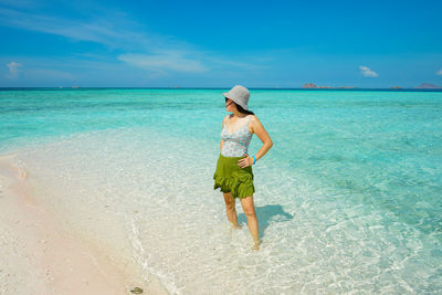 Rear view of woman standing at beach