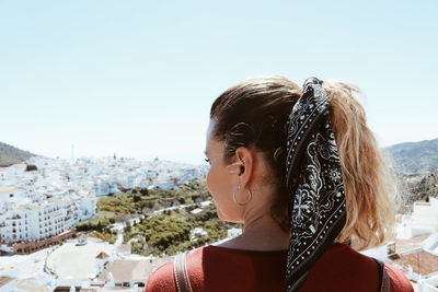 Rear view of woman looking away standing against sky