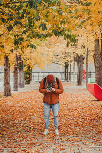 Full length of man standing on leaves during autumn