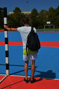 Rear view of man standing at basket ball court