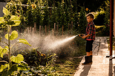 Boy standing by plants