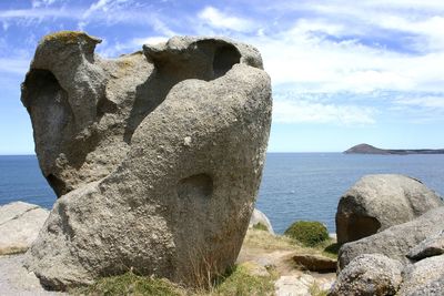 Close-up of rock by sea against sky