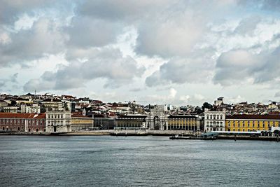 River in city against cloudy sky