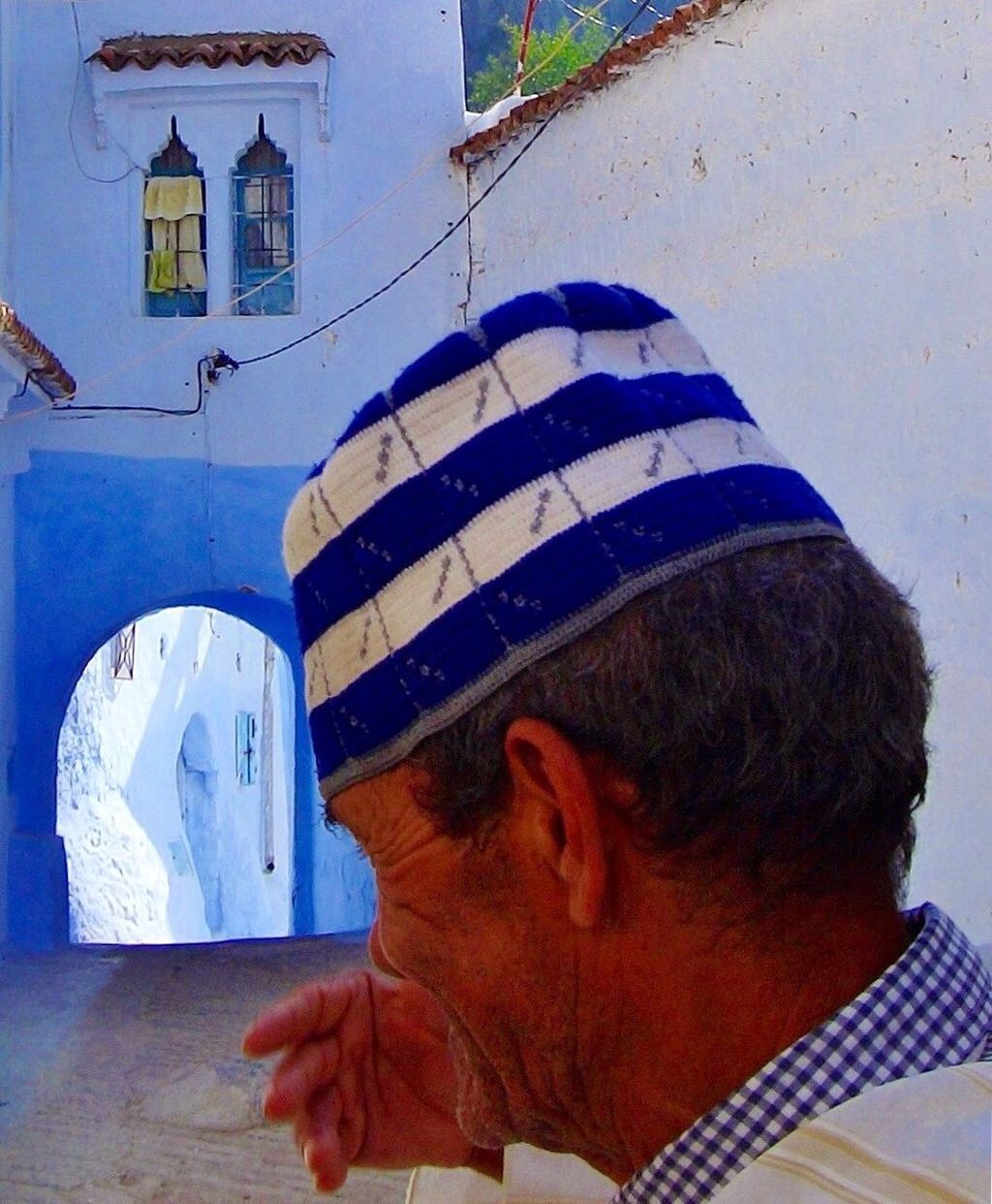 lifestyles, leisure activity, built structure, architecture, building exterior, headshot, holding, casual clothing, focus on foreground, rear view, day, person, men, wall - building feature, blue, outdoors, close-up, striped