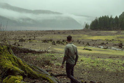 Man looking at tree stumps in landscape