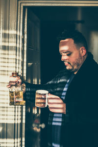 Portrait of a man choosing between coffe and alcohol 