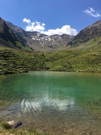 Scenic view of lake by mountains against sky