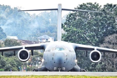 Airplane on airport runway against sky