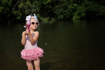 Girl wearing sunglasses while fishing in lake